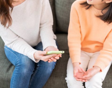 young asian mother and daughter,smart phone, hands